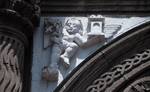 Façade portal, left spandrel relief, cherub