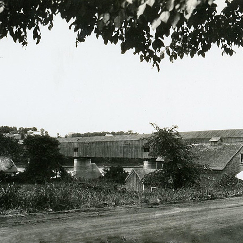 Early 20th century street composition of Hartland, New Brunswick and showing dirt roads, period homes and with the hi…