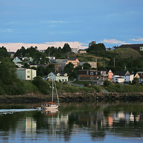 A sailboat approaches the Reversing Falls with the Lower Westside providing the backdrop.
