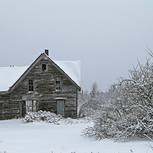 A house that has seen better days endures yet another winter blast.