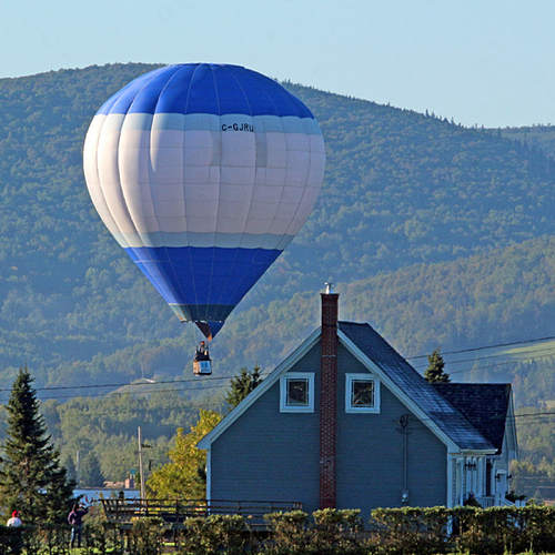 A hot-air balloon brushes past a rural home near Sussex, New Brunswick @ the Atlantic International Balloon Festival.