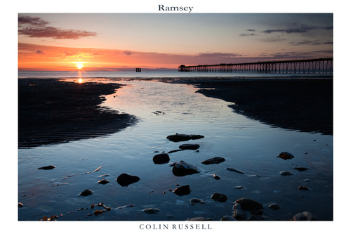 The sun rises over the Lake District Mountains and beams across the Irish Sea onto sunny Ramsey.