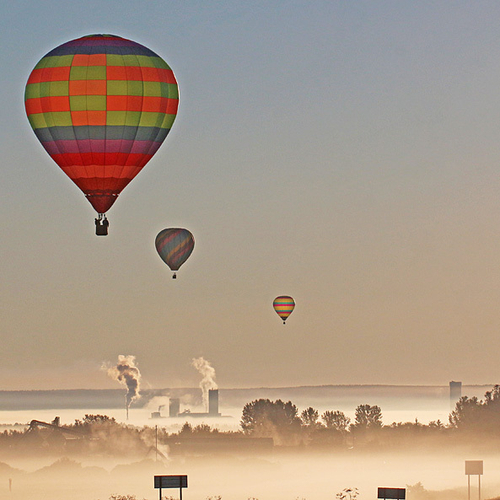 Hot-air balloons seem suspended in the thick morning mist of early September.