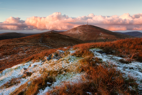 The golden first light of the day catches the Hills, Mountain and Clouds on a cold November morning.