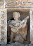 Façade niche sculpture, musician youth (right)