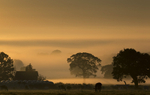 Sunrise over a misty countryside