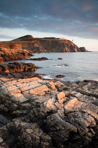 The first light of the day reflects off the coastline at Maughold Head.