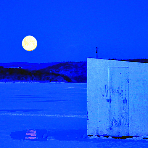 The February Snow Moon sets over an ice shack and the Kennebecasis River at Rothesay, New Brunswick