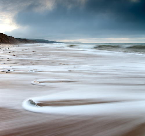 The sea rolls in and out at Kirk Michael on a cool February afternoon. Here looking South towards Peel.