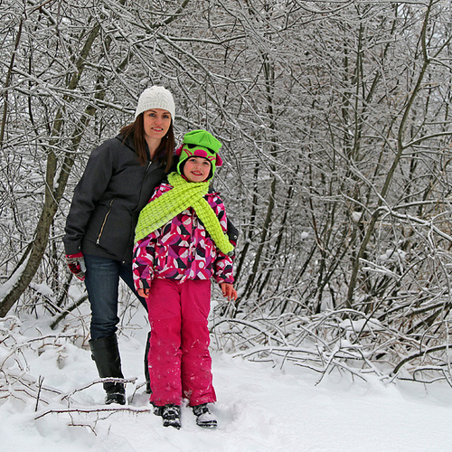 A mother & daughter pause for a pose in the winter wonderland.