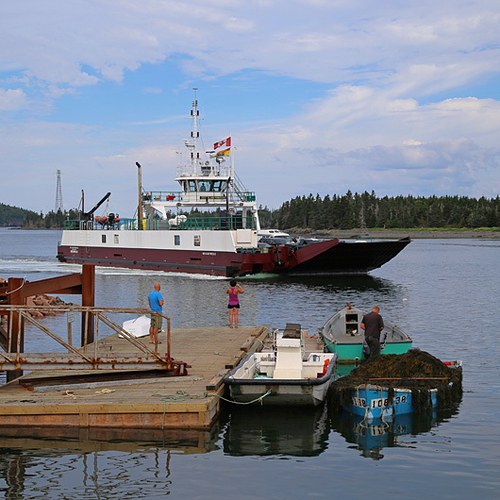 The Deer Island ferry, The Deer Island Princess II is seen coming into the L'Etete dock as tourists take pictures and…