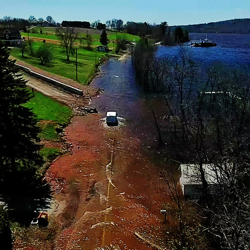 Vehicle braves the new found stream along Rt 850 and heads towards Bates Landing in rural Kings County amid the Great…
