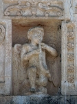 Façade niche sculpture, musician youth (left)