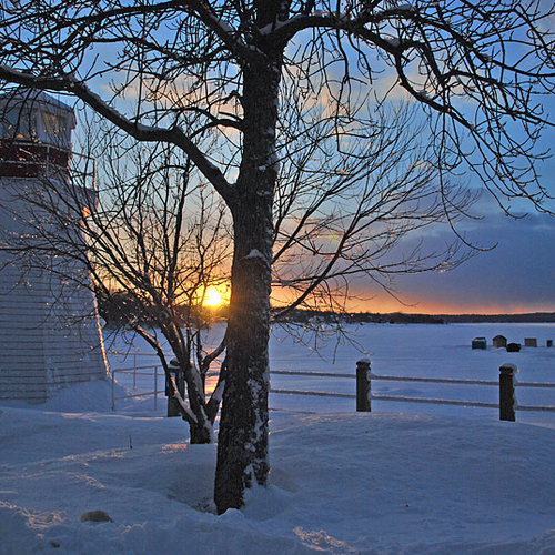 Sunset at Renforth, NB with the fishing shacks visible in the background and the lighthouse in the foreground.