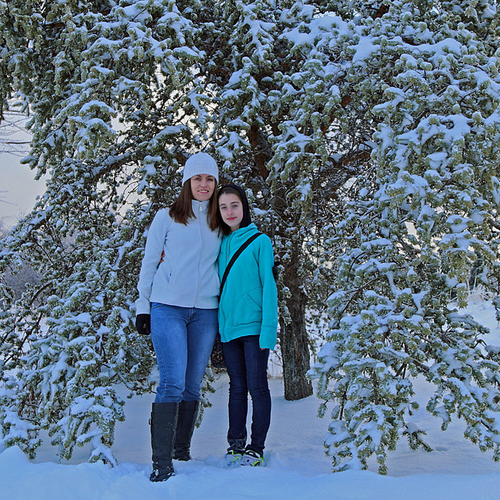 A jack pine tree laden by snow & ice makes a perfect framing for mother & daughter.