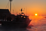 A fishing boats leaving Looe at sunrise on a winter morning