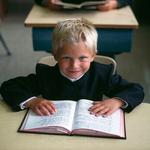 Young Hutterite Boy reading Bible, Alberta, Canada