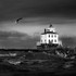 lighthouse with breaking waves b&w