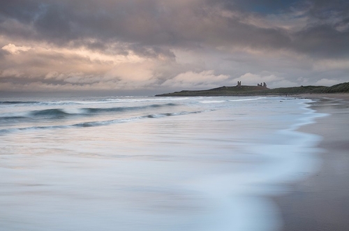 The winter sun catching the clouds out over the North Sea with just a hint of sunlight catching Dunstanburgh Castle.