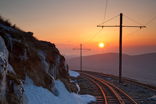 An icy Snaefell mountain railway contrasting with the hazy sunset.