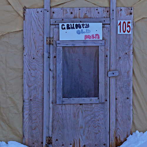 A door sign on an ice fishing shack says it all.