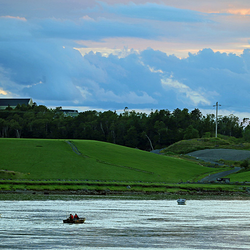 Boats converge at twilight at the Reversing Falls, just above the pulp mill and with the steeple of St. Rose of Lima…