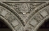 Lower cloister arch, archivolt almohadillado & spandrel relief (sun)