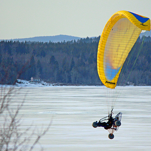 A power paraglider flies along the southern shore of the Kennebecasis river near Renforth, New Brunswick.