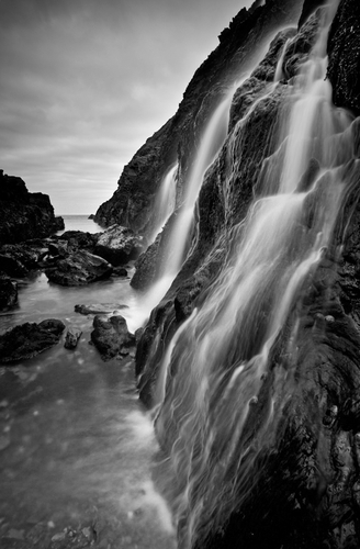 A small stream cascades down the rock face into a ravine on the East Coast of the Isle of Man. The long exposure enha…