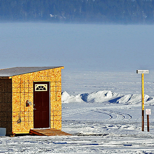 With axe over shoulder, an ice fisherman heads out for another day of action on the frozen Kennebecasis River.