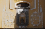 Façade, niche sculpture (St. Francis) flanked by Franciscan insignia