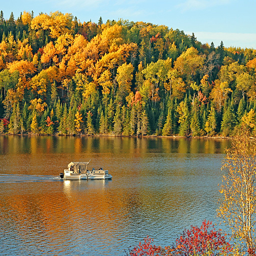 A small boat cruises up the Tobique River in North Central New Brunswick.
