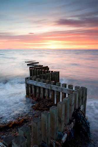 Summer sunset on the West coast at Glen Mooar with its single zig zagging groyne