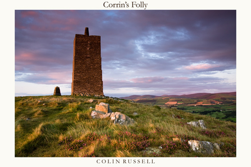 Corrin's Folly at the top of Peel head, catching the last rays of sunlight, with the hills and Mountain of Snaefell i…