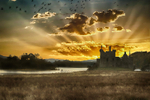 A stunning array of sunrays behind Kilchurn Castle