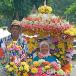 Happy smiling couple in a Colourful floral rickshaw, Melaka, Malaysia