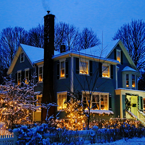 A homestead beautiful lit with festive, seasonal lights.