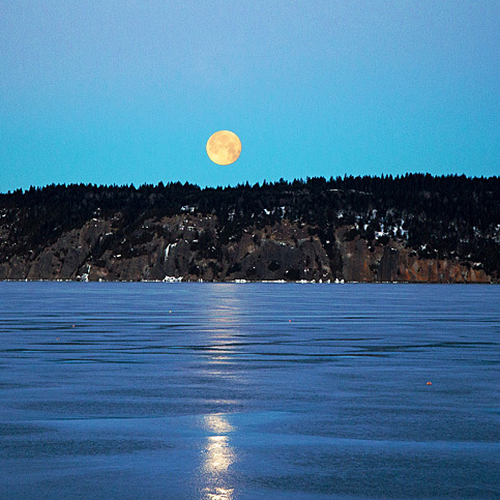 The full moon sets over Long Island and the Minister's Face on a cold winter's morn.