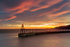 Sun rising behind Whitby's East Pier