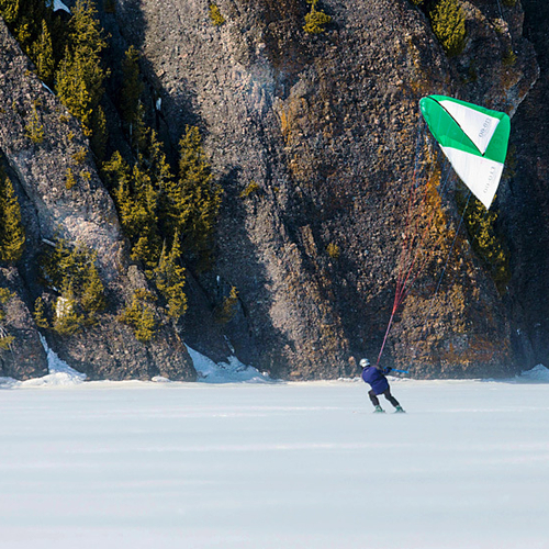 A snowkiter shoots past the steep cliff face along the southern shores of Long Island.