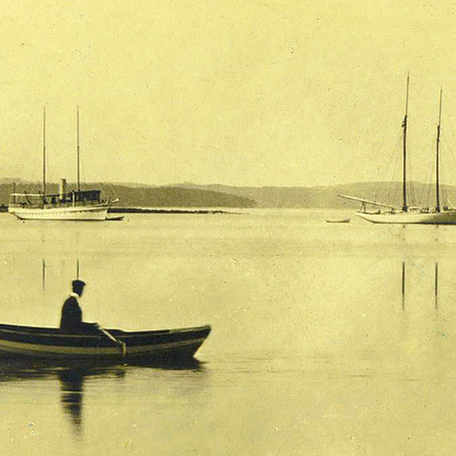 Late 19th century peek at a man in a row boat and with yachts moored off of Rothesay Park and looking towards Renfort…