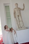 Two little brides maids giggling at statue in Margam Orangery