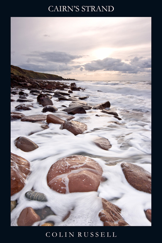 Frothy sea at Cairn's Stand, North of Peel, with Peel Castle in the distance.