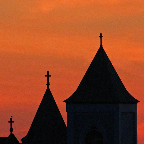 Church steeples silhouetted by a brilliant sunset become prominent in the skyline at Saint John, New Brunswick.