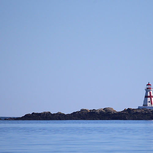 A sailboat passes by East Quoddy Lighthouse on Campobello Island.