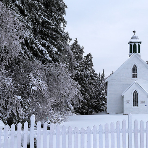 A white country church seems suddenly camouflaged after a touch of Old Man Winter.
