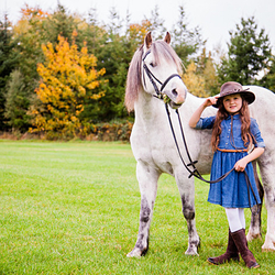 grey pony and girl in cowgirl outfit