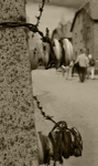 Auschwitz fence detail and buildings sepia