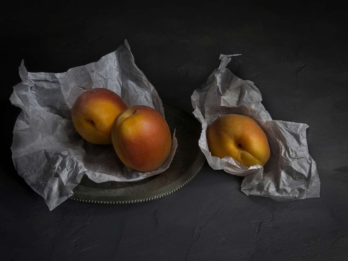 Three Apricots. Light-painted still-life in the style of Eliot Hodgkin. Lit with diffused torchlight.