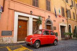 An old red Fiat 500 on the streets of Rome, Italy